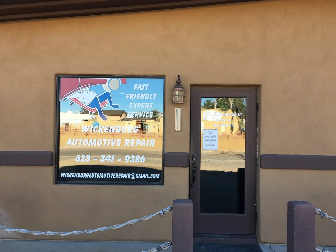 The storefront of Wickenburg Automotive Repair with its painted window sign and front door